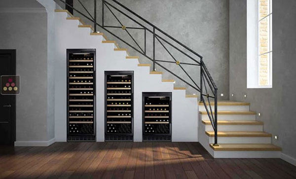 trois cave à vin encastrable sous un escalier